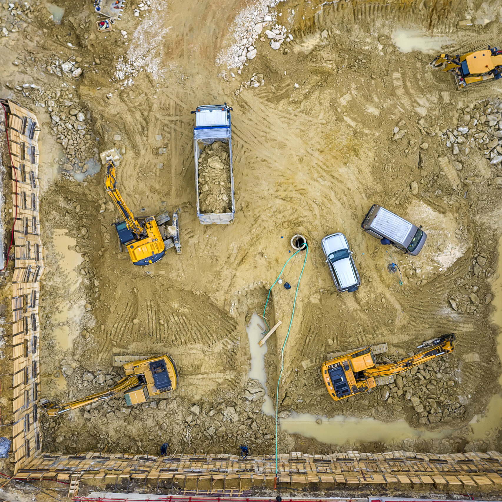 Heavy construction equipment working at the construction site. Aerial view from drone